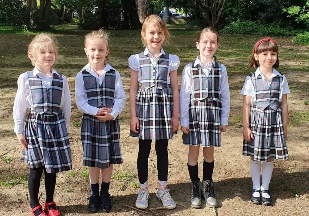 5 children outside junior school children in uniform outside